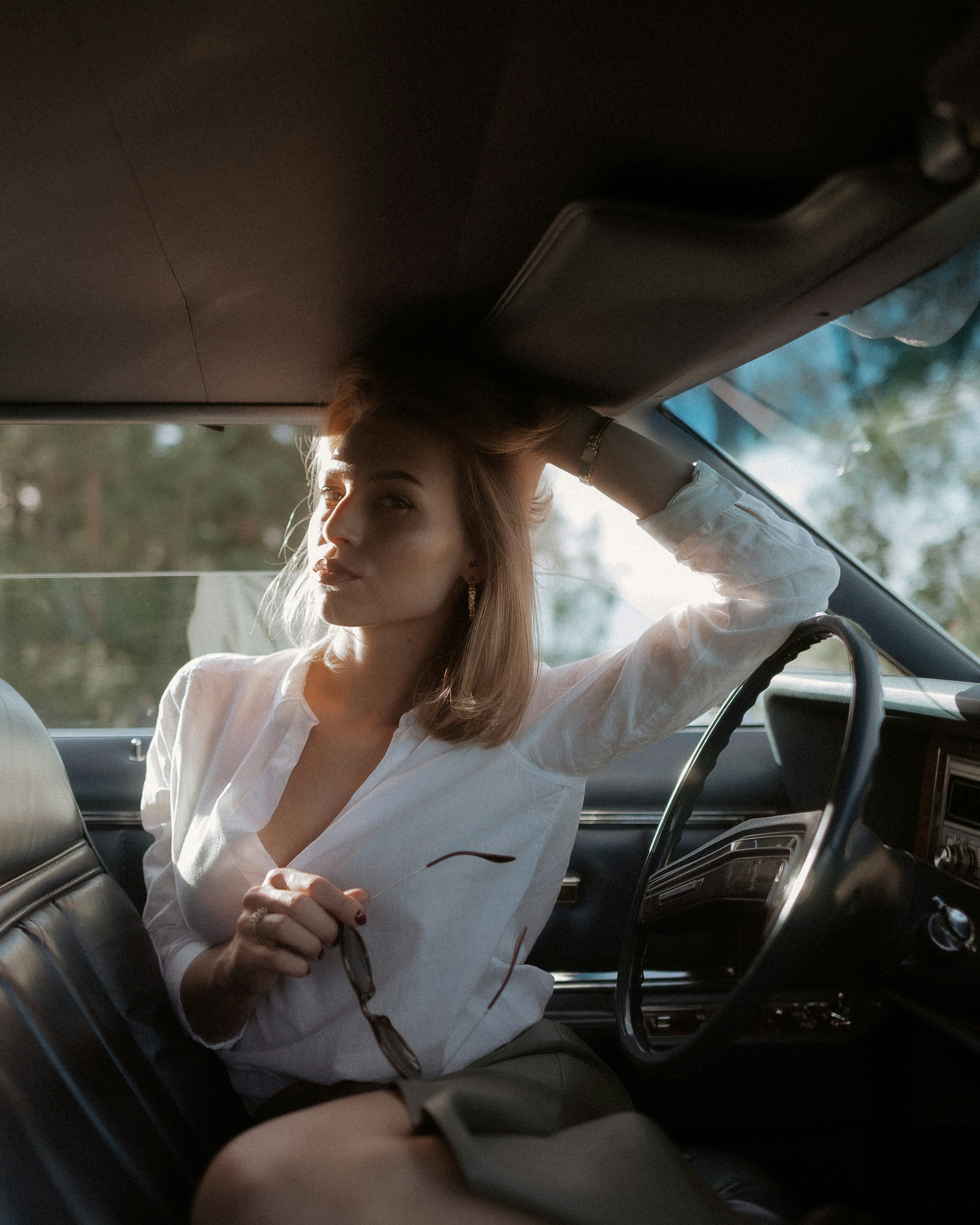 woman in white long sleeve shirt driving car